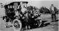 Groupe de six enfants assis sur le capot d'une automobile, avec leur pre, Andr Ct, en retrait
