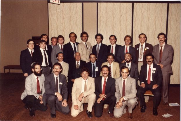 Vingt-trois hommes portant veston-cravate disposés en trois rangées.