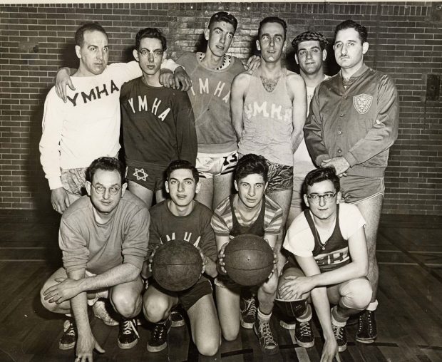 Dix jeunes hommes posant pour une photographie de l’équipe en maillots de la YMHA.