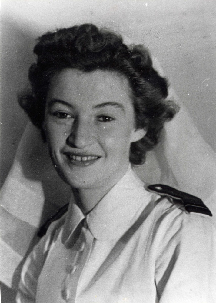 Portrait officiel d’une jeune femme portant le voile blanc et l’uniforme blanc des infirmières militaires.