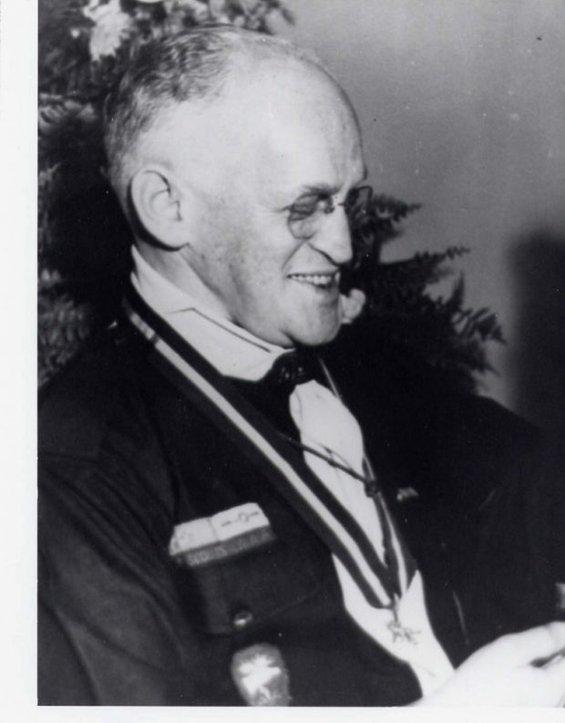 Portrait d’un homme, de profil, portant un uniforme de chef des scouts.