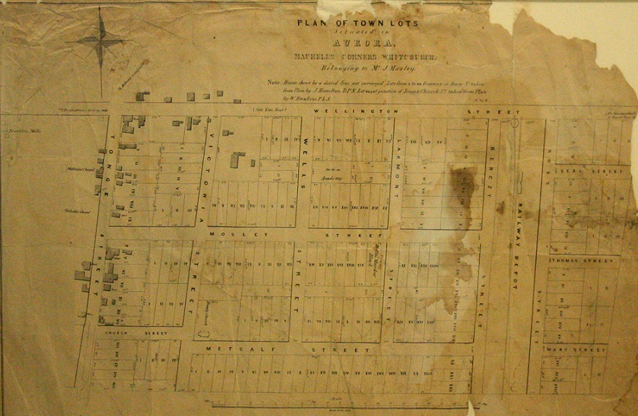 Une vieille carte froissée, tachée et déchirée montre le quadrillage des  parcelles  constructibles d’Aurora avec les numéros des lots et les noms des rues.