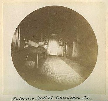 Photo ronde en noir et blanc montrant un hall d’entrée, plusieurs chaises et un tapis long.