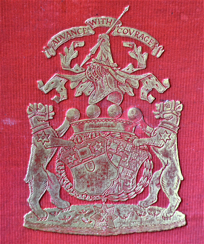 Armoiries de famille argentées sur fond rouge composées de deux lions flanquant des boucliers avec la devise « Advance with Courage » (avancer avec courage) au-dessus.