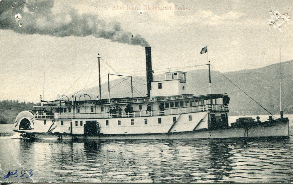Carte postale en noir et blanc représentant un grand bateau à aubes avec deux ponts et de la fumée s’élevant de la cheminée.