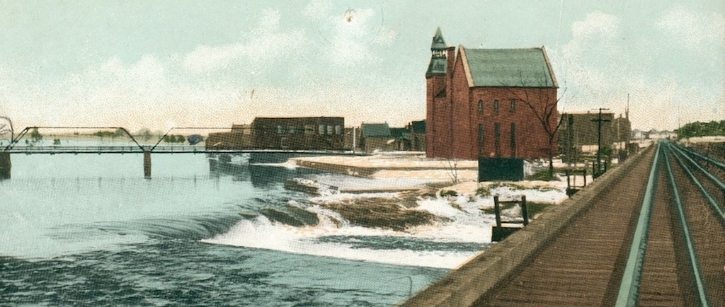 Photographie en couleur du pont de la voie ferrée en direction d’Almonte avec une vue de l’hôtel de ville