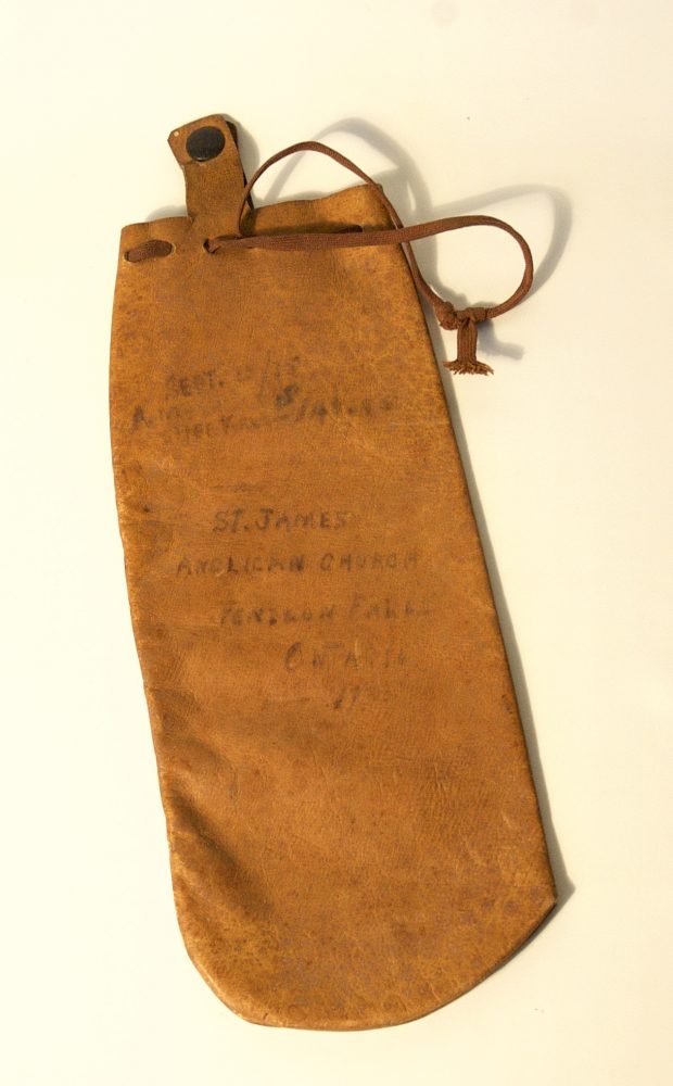 Petite pochette en cuir avec cordons de serrage et texte écrit à la main sur le tissu.