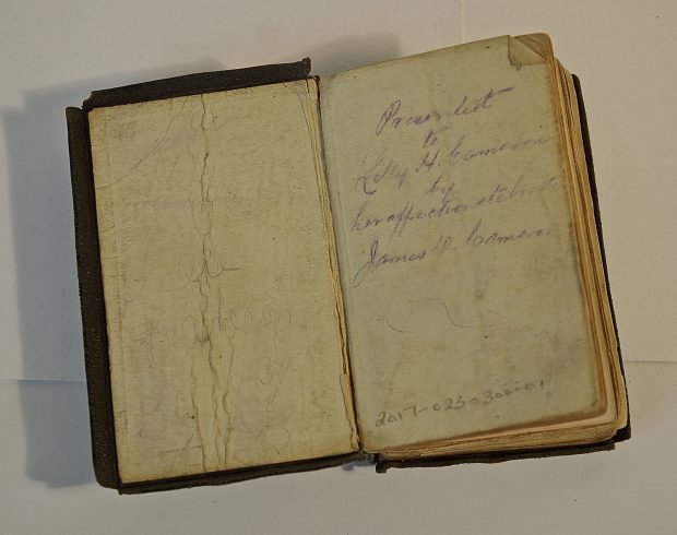 Une petite bible d'enfant montre l'état délicat de la petite bible d'enfant. L'inscription à l'encre violette indique Presented to Lilly H. Cameron by her affectionate brother James D. Cameron. 