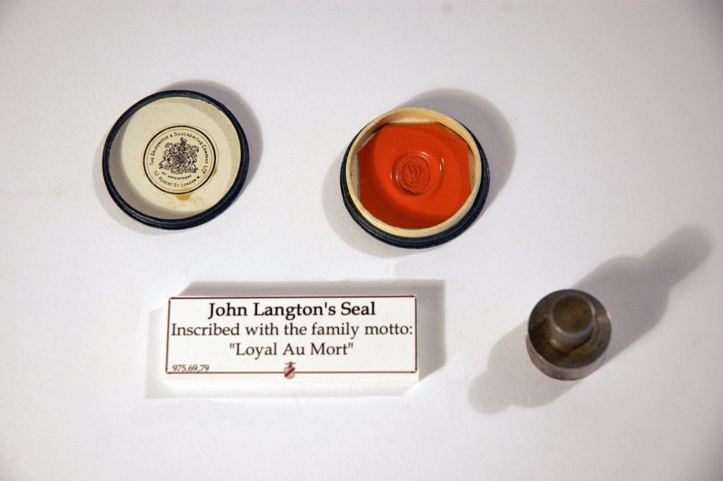 Mesurant un peu moins de 2 pouces de diamètre, la photo montre le sceau rouge de John Langton, portant la devise familiale Loyal Au Mort. Le couvercle de la boîte à sceaux se trouve à gauche du sceau. À droite du sceau, on voit l'encre qui aurait été appliquée.