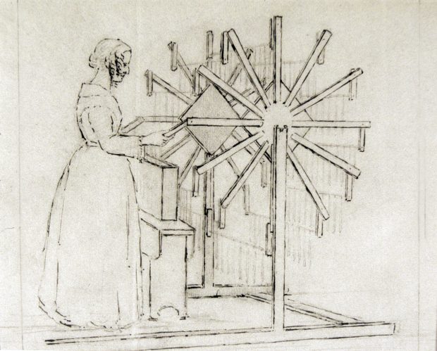 Croquis au crayon de charbon de bois du début du 19e siècle. Une femme se tient debout devant une structure ronde en bois. Il y a 12 bras de chaque côté, chacun tenant une bougie.