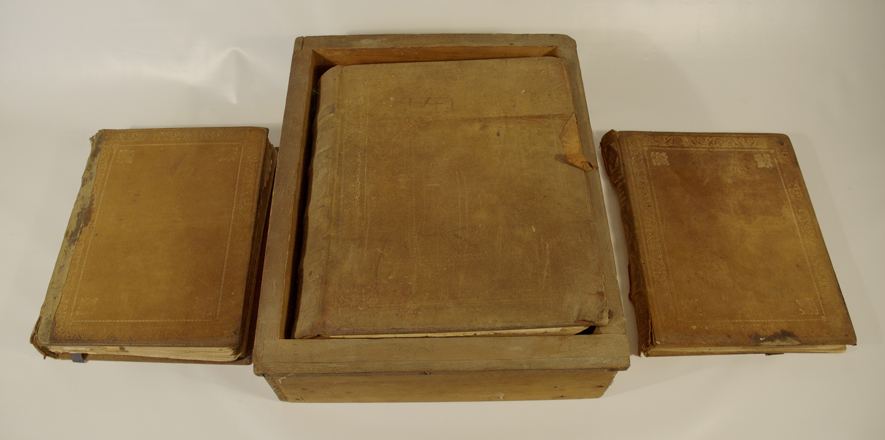 Ensemble de livres d'autel trouvés à St. James. Les couvertures sont en cuir brun clair usé. L'évangéliaire se trouve dans une boîte simple, tandis que le livre de communion et le livre de prières sont placés de part et d'autre de l'évangile.