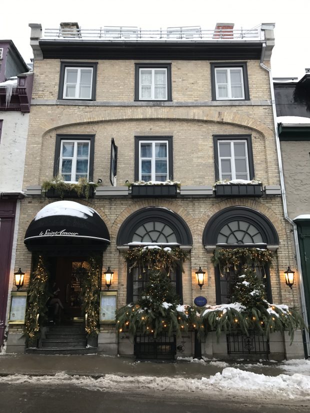 Photographie récente représentant un bâtiment en brique de trois étages. De chaque côté, on retrouve des bâtiments similaires séparés par des murs mitoyens.  