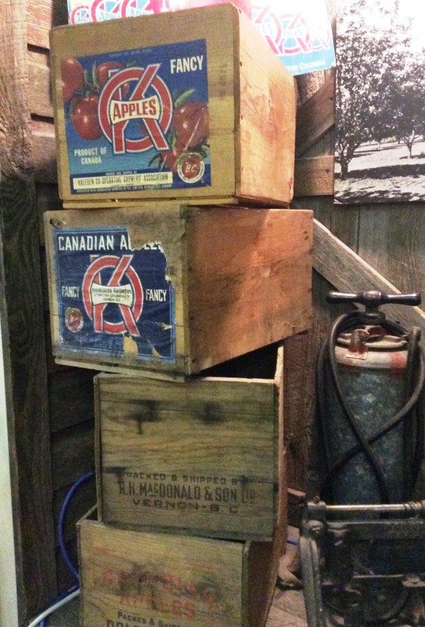 Photo en couleur représentant une pile de caisses de pommes en bois. Les deux caisses du haut portent des étiquettes de la marque OK.