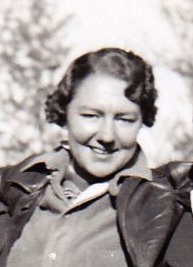 Photo en noir et blanc représentant une femme d’une trentaine d’années souriant au photographe.