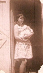 Jane Hayse avec un petit bébé. Cette photo montre Jane Hayse juste avant qu’elle quitte Parker’s Cove pour aller travailler à St. John’s.