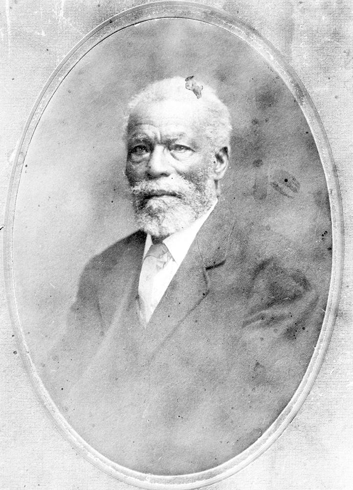 portrait studio professionnel en noir et blanc dans un cadre ovale, homme âgé aux cheveux blancs, barbe et moustache, en costume formel et cravate