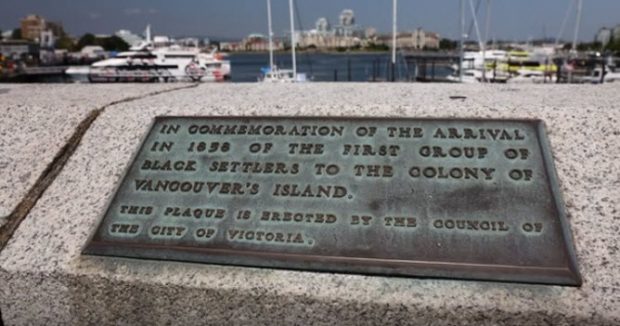 plaque de bronze incrustée dans la partie supérieure d’un mur en béton de la chaussée