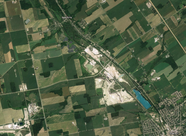 Une image satellite des routes, des carrières et des terres agricoles entre un village et une ville