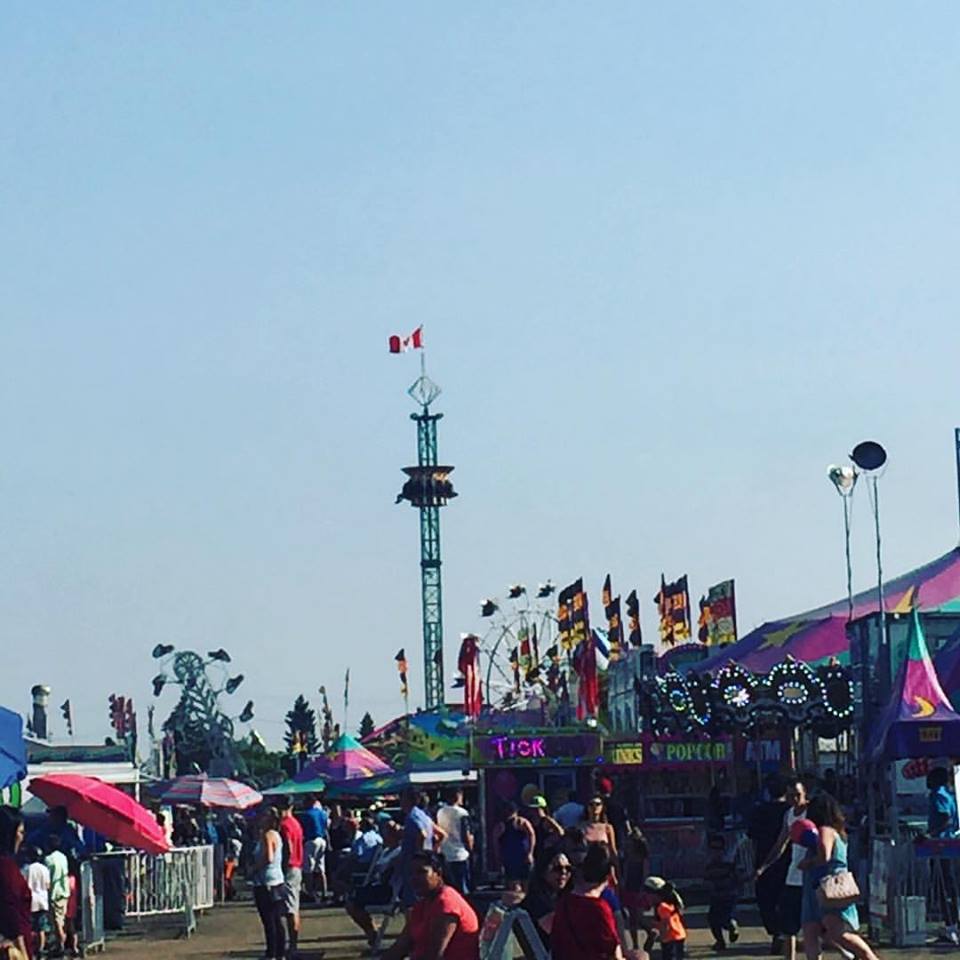 Les attractions d’une fête foraine comprenant des manèges et des stands, on voit un carrousel à l’avant, et en arrière-plan, les manèges Zipper, Super Hot et une grande roue