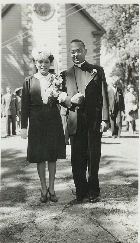 Photo en noir et blanc d’Esther Taylor (à gauche) et de son mari le révérend Burgess (à droite) devant l’église St. Peter’s le jour de leur mariage.