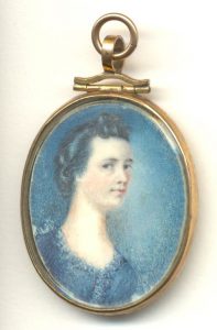 Médaillon en or avec le portrait d’une femme aux cheveux bruns portant une robe bleue. 