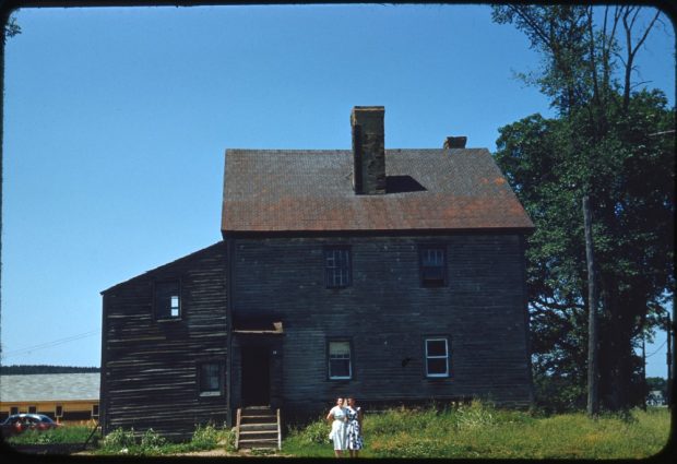 Photo en couleurs de deux femmes debout devant une vieille maison