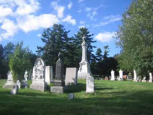 Photo en couleurs du cimetière commémoratif Alexander Gibson avec de l’herbe verte et des pierres tombales en arrière-plan.