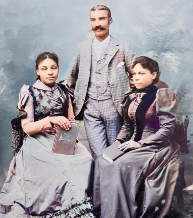 Photo colorisée de trois personnes de couleur bien habillées. Mary Matilda Winslow est assise à gauche, son père est debout derrière elle et sa mère est assise à droite.