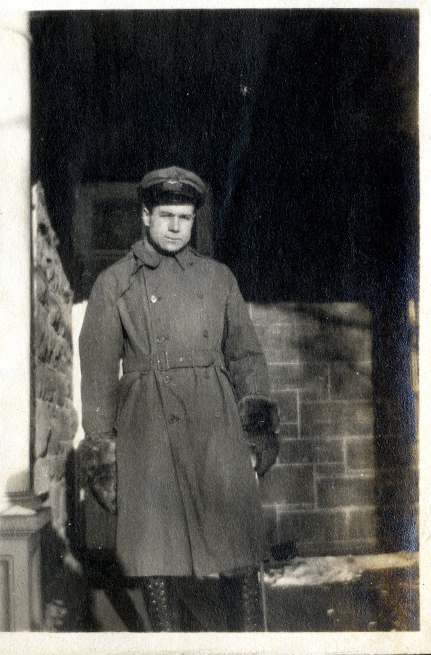 Homme en uniforme militaire debout sur une véranda.