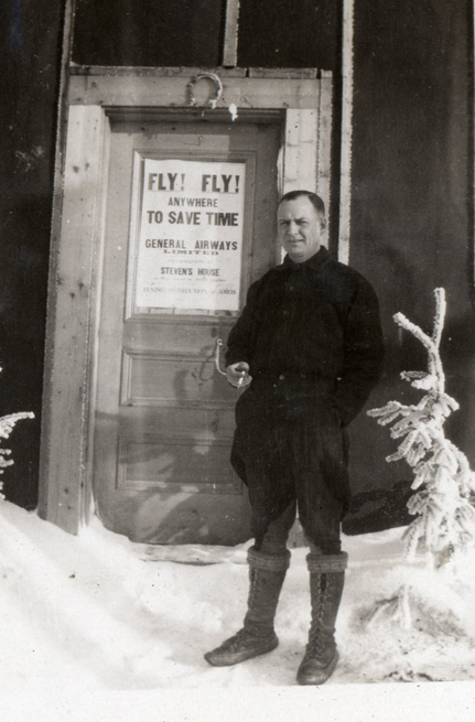 Homme debout dans la neige devant une porte. 