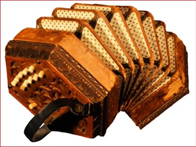 Photographie couleur d'un accordéon concertina brun de forme hexagonale, le soufflet en extension.