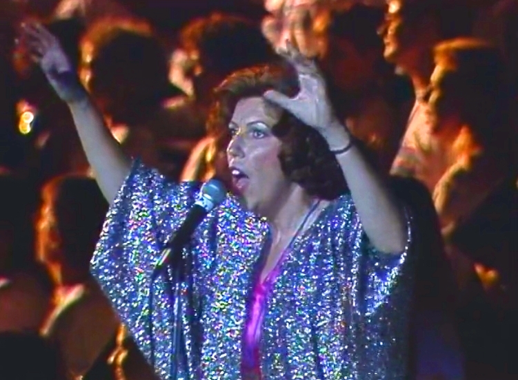   La soliste Joelle Rabu chante lors des cérémonies de clôture de Celebration '90 avec un refrain en photo derrière elle.