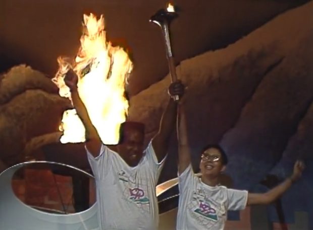 Les porteurs de flambeau Woolly Taylor et Marlene Wong lèvent les bras en triomphe après avoir allumé la flamme de la célébration 90 à B.C. Place Stadium.