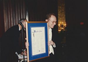 Le directeur musical Stephen Glass tient un grand certificat.