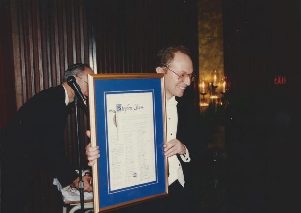 Le directeur musical Stephen Glass tient un grand certificat.