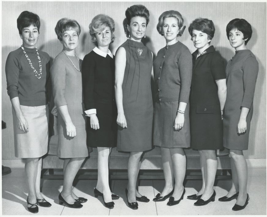 Une photographie formelle en noir et blanc d’un groupe de femme dans une tenue des années 1960.