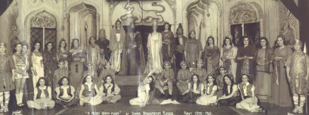 Une photographie en noir et blanc d'un groupe d'enfants costumés pour une pièce de théâtre.