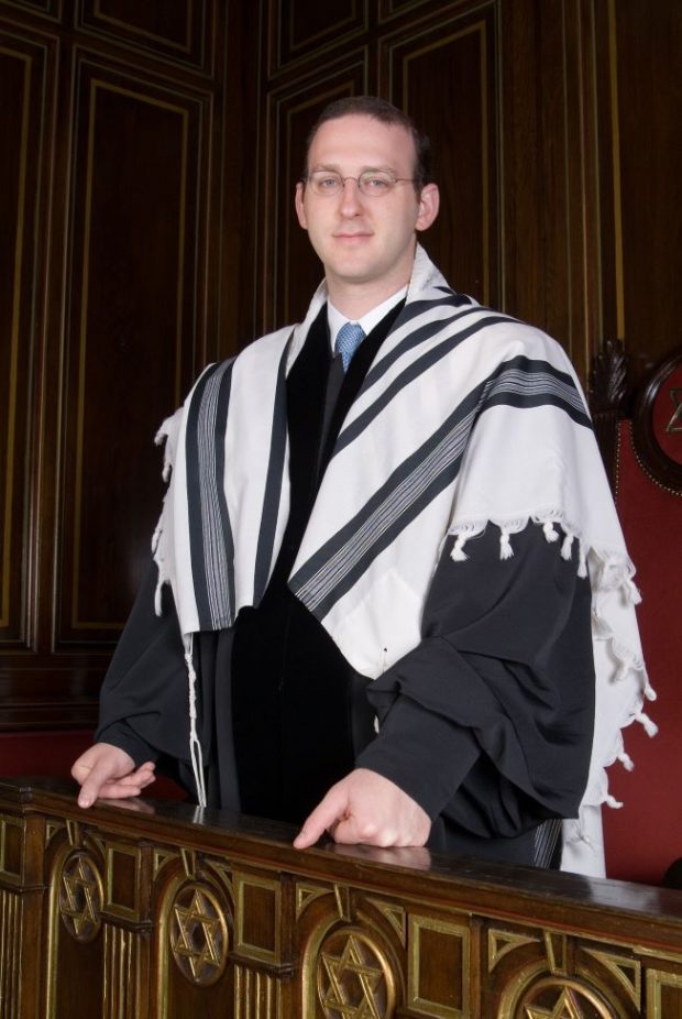 Le rabbin Adam Scheier vêtu de vêtements cérémoniels et d’un châle de prière.