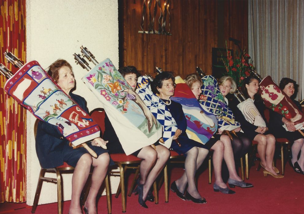 Un groupe de femmes assises tiennent des rouleaux de la Torah.