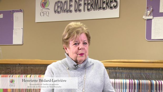 Plan rapproché d'une femme aux cheveux courts et blonds portant un col roulé gris. Elle est devant un métier à tisser. Dans le coin inférieur, sur un bandeau, on peut lire qu'il s'agit d'Henriette Bédard-Larivière, responsable de l'atelier de peinture du Cercle de Fermières de Saint-Eustache.