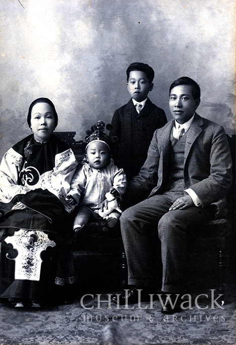 Portrait de groupe formel en noir et blanc dont on pense qu’il représente la famille Yip On. Le plus jeune des enfants est au centre, une couronne sur la tête, la mère est à gauche et le père, à droite. Leur jeune fils se tient debout, légèrement sur le côté, derrière la famille assise.