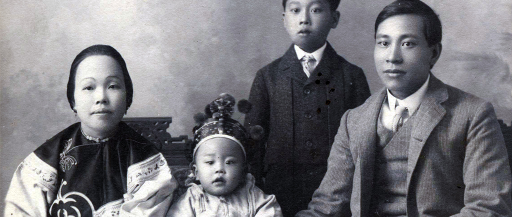 Portrait de groupe formel en noir et blanc dont on pense qu’il représente la famille Yip On. Le plus jeune des enfants est au centre, une couronne sur la tête, la mère est à gauche et le père, à droite. Leur jeune fils se tient debout, légèrement sur le côté, derrière la famille assise.