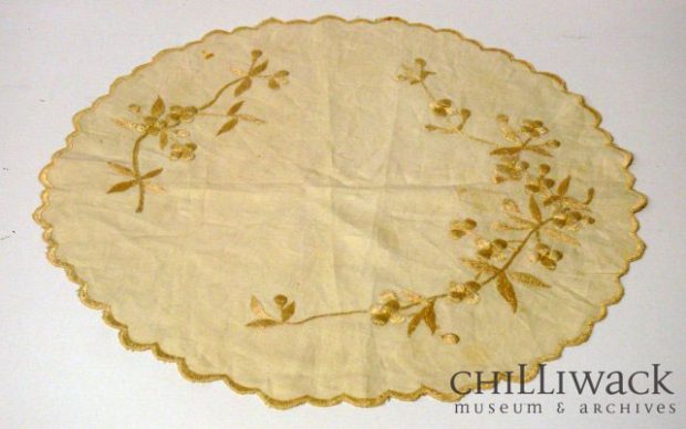 Nappe ronde en coton de couleur crème avec une bordure festonnée et un motif floral brodé