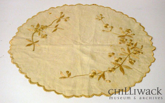 Nappe ronde en coton de couleur crème avec une bordure festonnée et un motif floral brodé