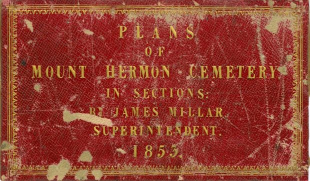 Photo couleur d'une page de couverture rouge et or des plans du cimetière Mount Hermon par James Miller. La couverture est vieille et en lambeaux, et les mots sont écrits en lettres dorées.