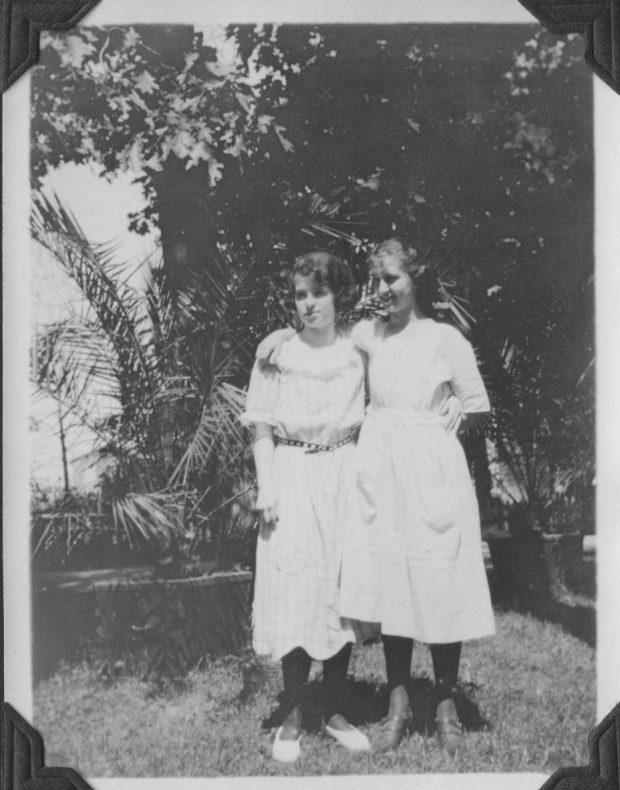 photo noir et blanc deux jeunes filles vêtues de blanc en été. Entouré de plantes tropicales de la serre en arrière-plan.