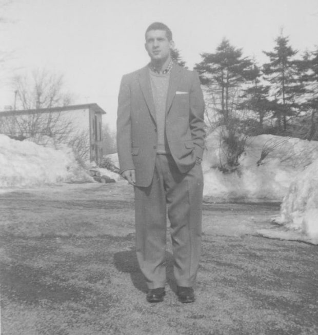 Photo grise d'un homme debout devant un bâtiment 