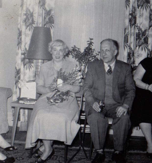 Photo noir et blanc d'un couple de personnes âgées lors d'une fête habillée de la meilleure façon qui leur est assise près d'une grande fenêtre