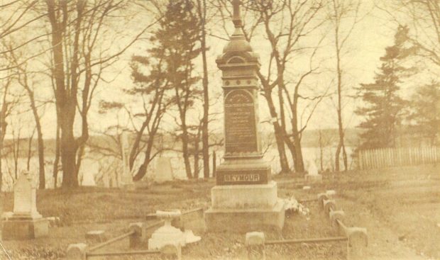 sépia image d'un monument entouré d'arbres et a une vue sur la rivière derrière le monument.