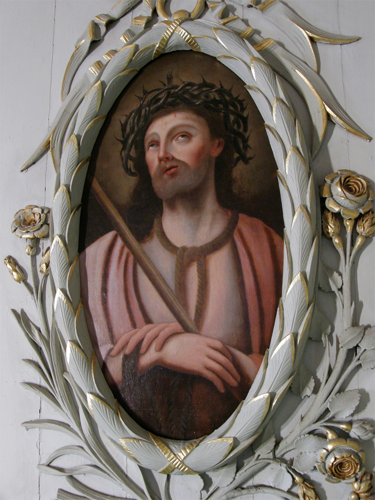 Photographie couleur, plan rapproché, dans un cadre ovale en bois sculpté et décoré à la feuille d’or, une peinture représentant un homme les yeux au ciel et portant une couronne d’épines sur la tête.